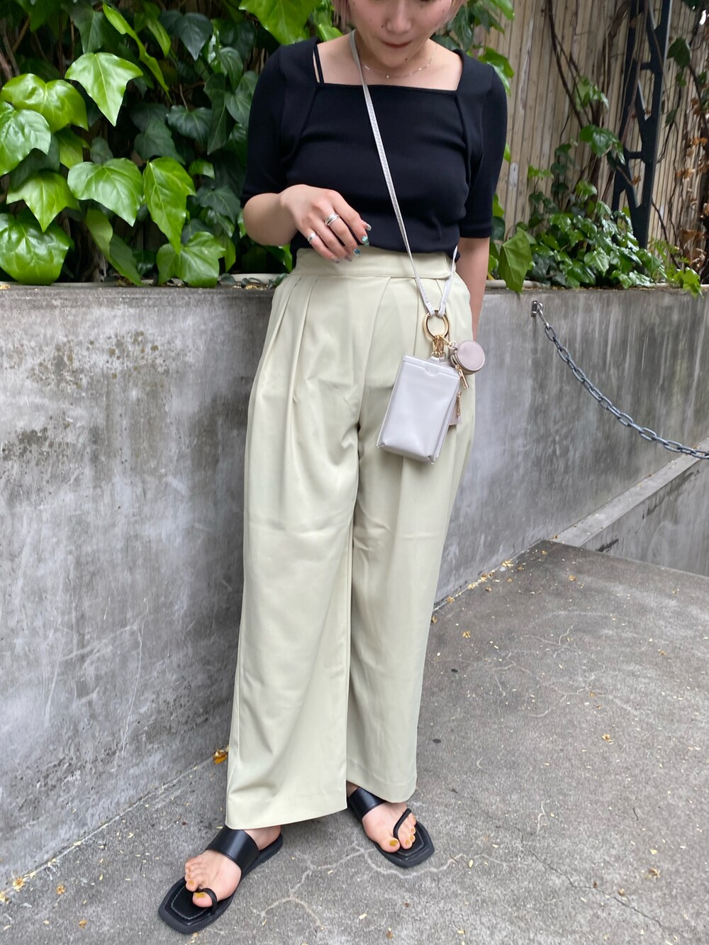 ブラック系のパンプス、グリーン系のその他パンツ、ベージュ系のショルダーバッグを着用したレディースの春コーディネートの2枚目の写真