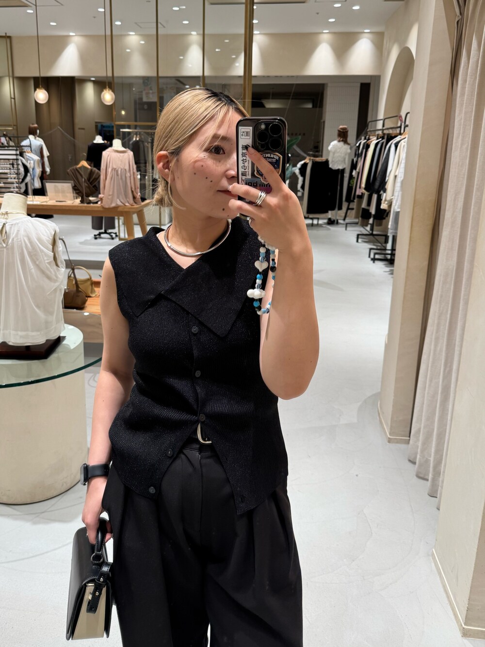 ブラック系のニット/セーター、ブラック系のショルダーバッグ、ブラック系のその他パンツを着用したレディースの夏コーディネートの2枚目の写真