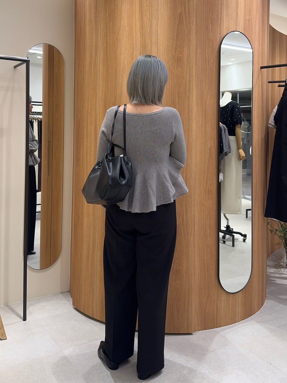 ブラック系のその他パンツ、ブラック系のトートバッグ、グレー系のニット/セーターを着用したレディースの秋コーディネートの3枚目の写真