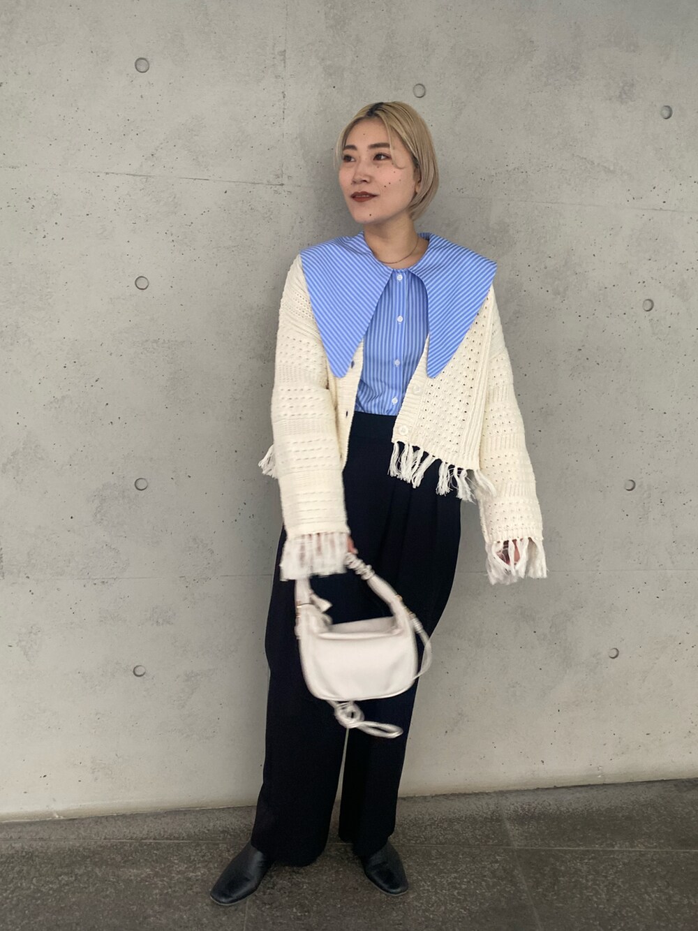 ホワイト系のハンドバッグ、ブルー系のシャツ/ブラウス、ブラック系のその他パンツを着用したレディースの冬コーディネートの3枚目の写真