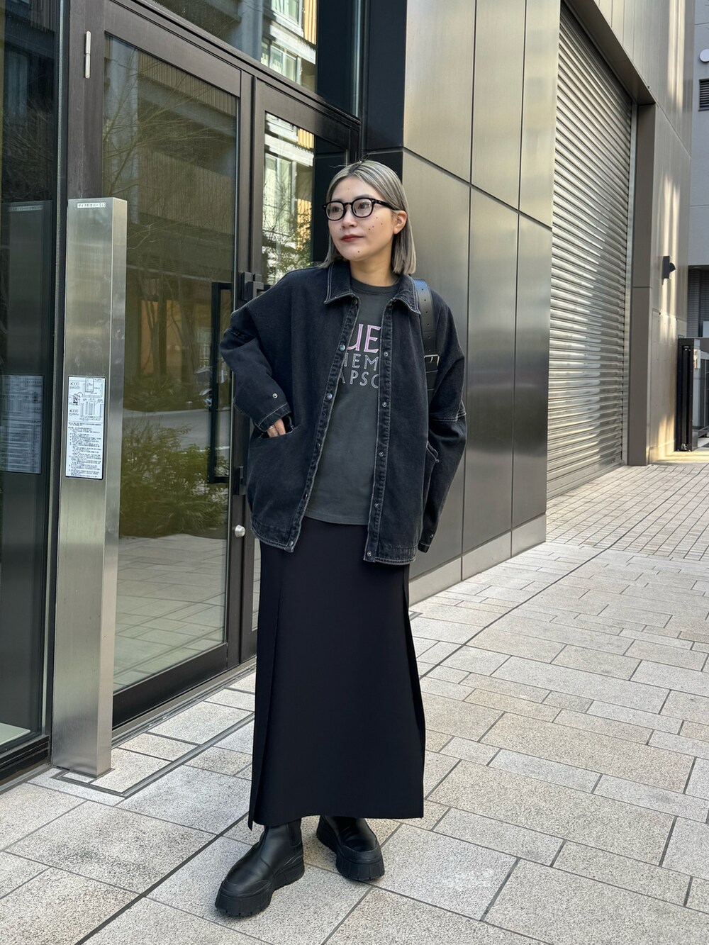 ブラック系のデニムジャケット、ブラック系のTシャツ/カットソー、ブラック系のスカートを着用したレディースの冬コーディネートの2枚目の写真