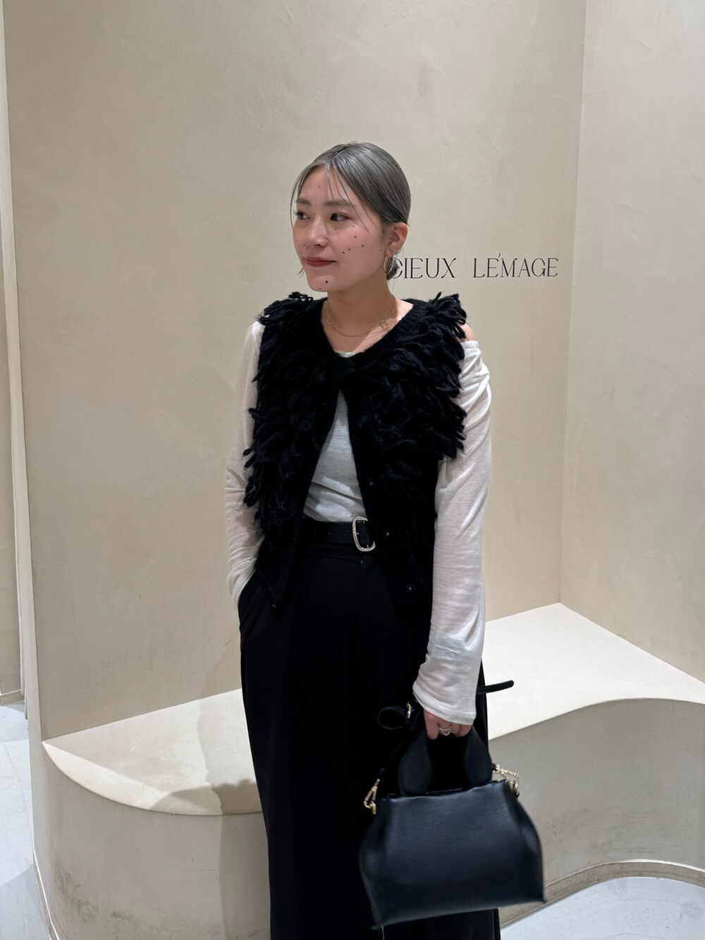 グレー系のTシャツ/カットソー、ブラック系のベスト、ブラック系のその他パンツを着用したレディースの冬コーディネートの2枚目の写真