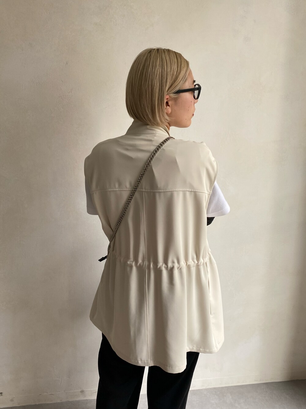 ブラック系のショルダーバッグ、ホワイト系のTシャツ/カットソー、ホワイト系のベストを着用したレディースの春コーディネートの3枚目の写真