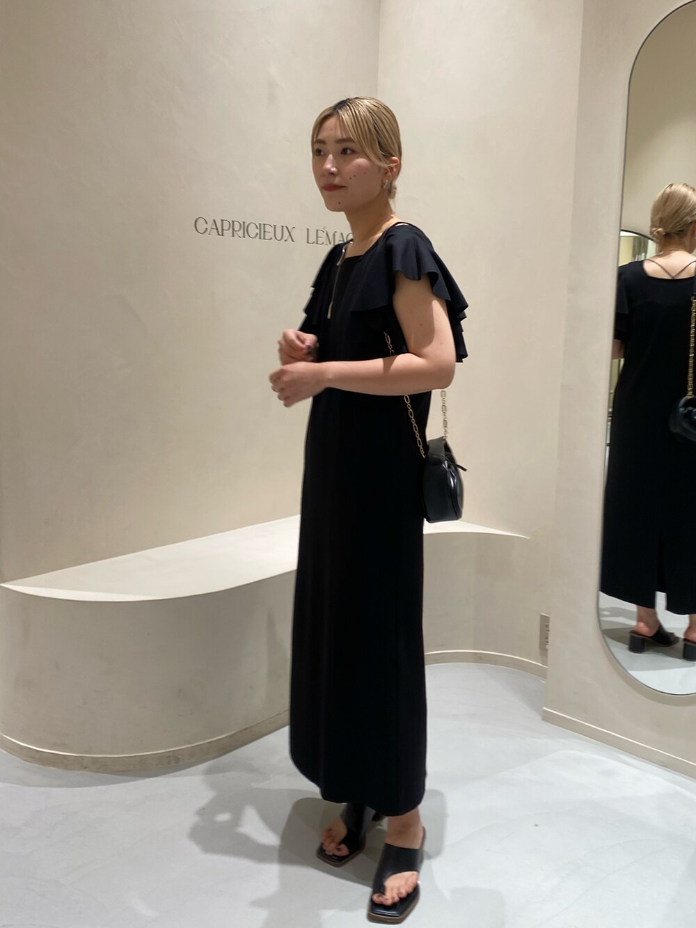 ブラック系のサンダル、ブラック系のワンピースを着用したレディースの夏コーディネートの2枚目の写真