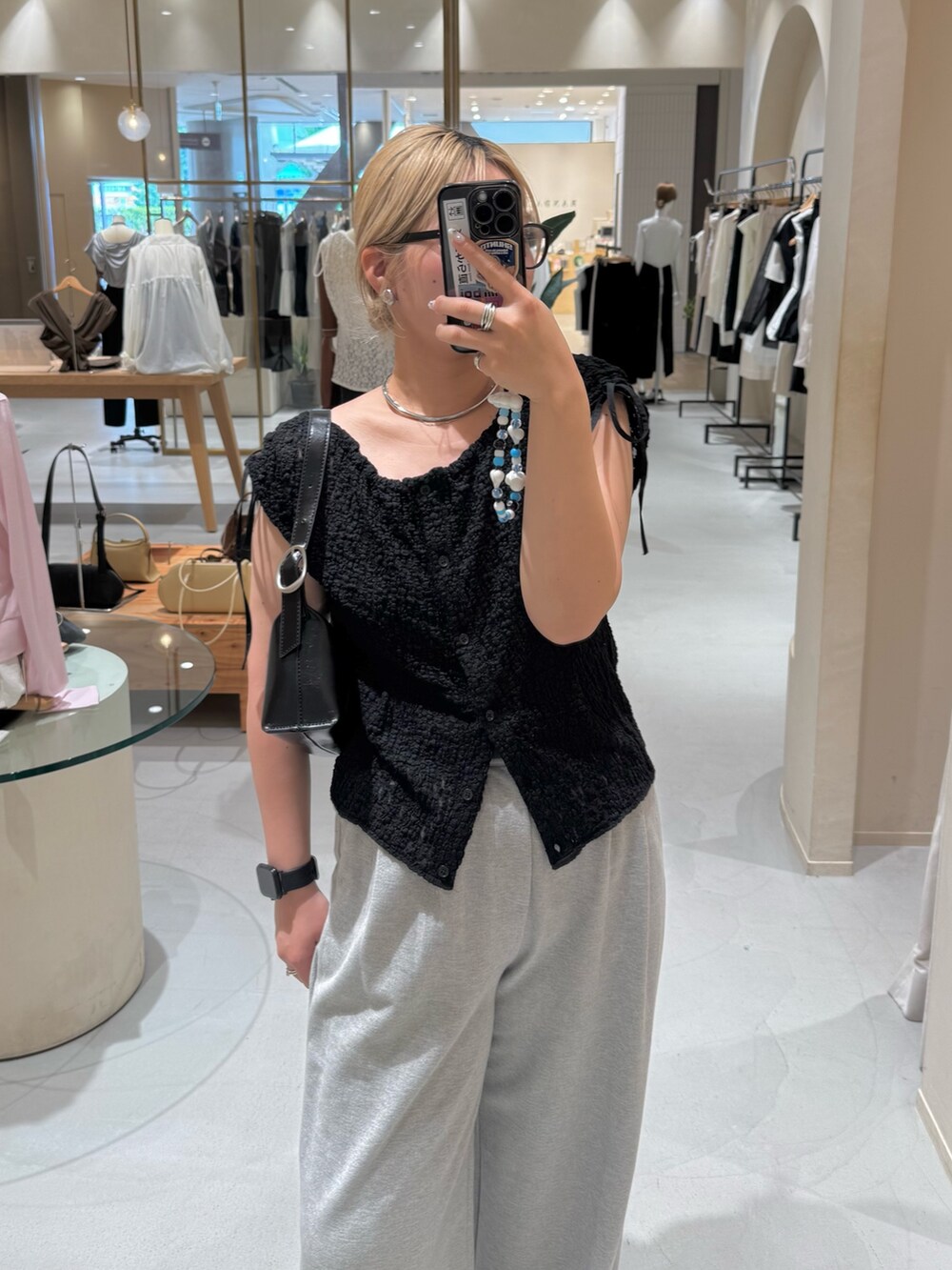 グレー系のその他パンツ、ブラック系のショルダーバッグ、ブラック系のシャツ/ブラウスを着用したレディースの夏コーディネートの2枚目の写真