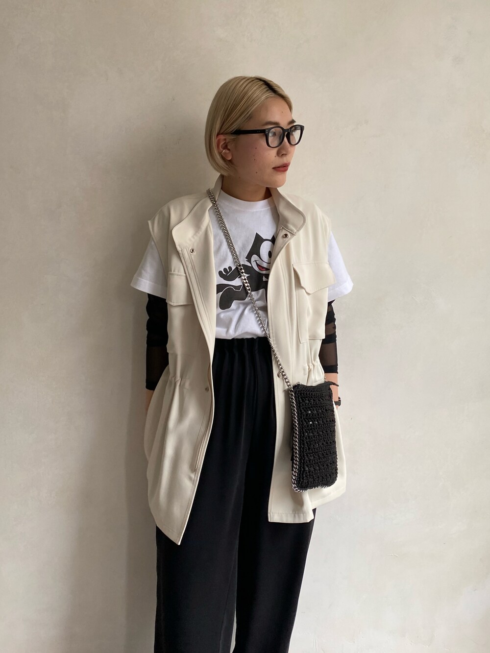 ブラック系のショルダーバッグ、ホワイト系のTシャツ/カットソー、ホワイト系のベストを着用したレディースの春コーディネートの2枚目の写真