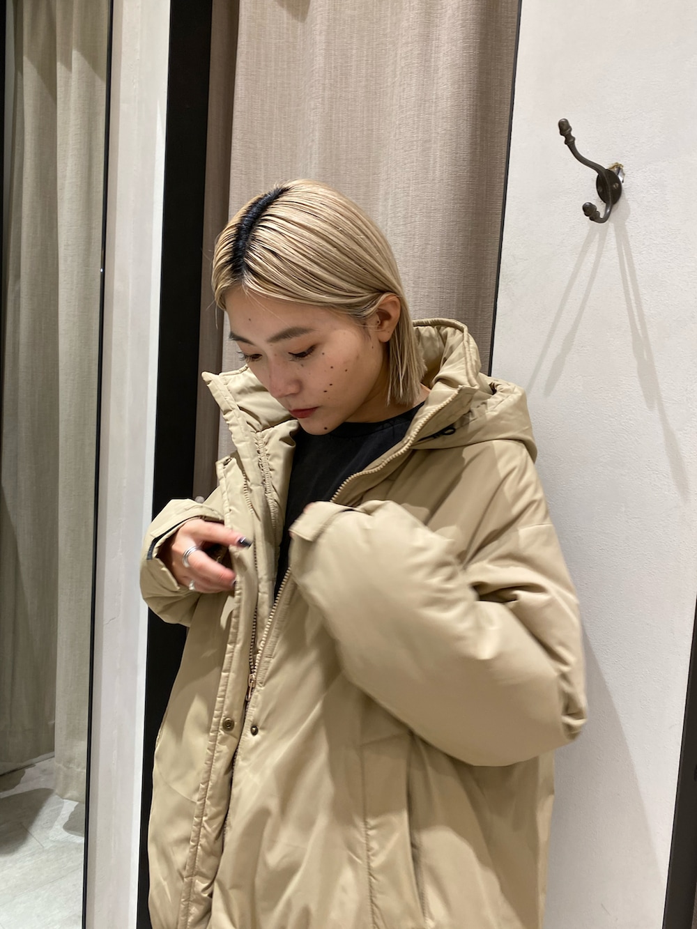 ベージュ系のダウンジャケット/コート、ブラック系のスカート、ブラック系のブーツを着用したレディースの秋コーディネートの3枚目の写真