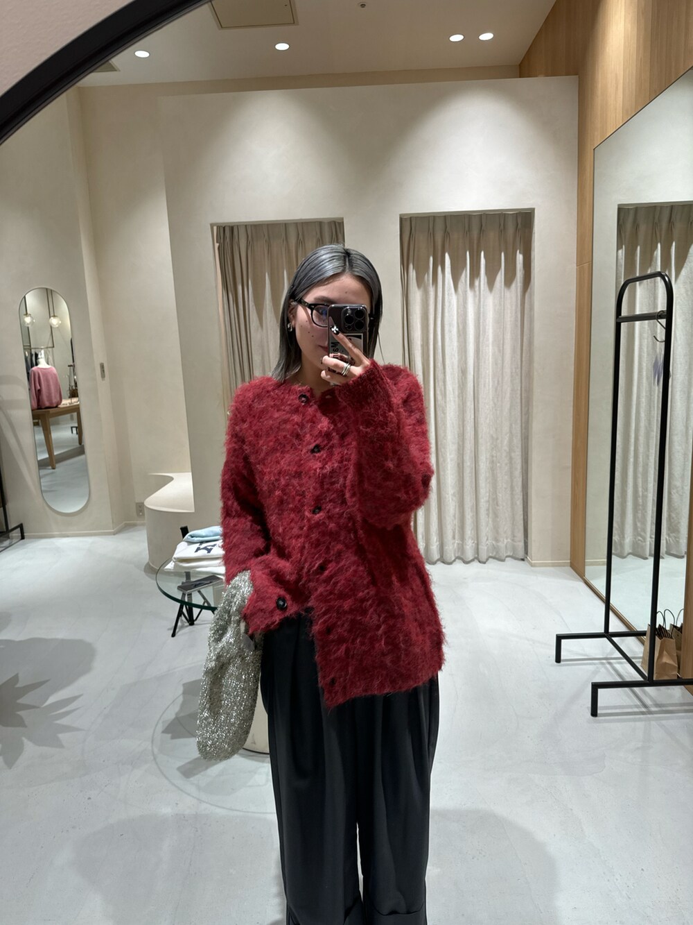 ブラック系のブーツ、レッド系のカーディガン/ボレロ、グレー系のその他パンツを着用したレディースの冬コーディネートの2枚目の写真