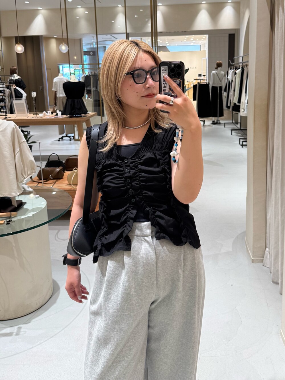 ブラック系のシャツ/ブラウス、グレー系のその他パンツ、ブラック系のボストンバッグを着用したレディースの夏コーディネートの2枚目の写真