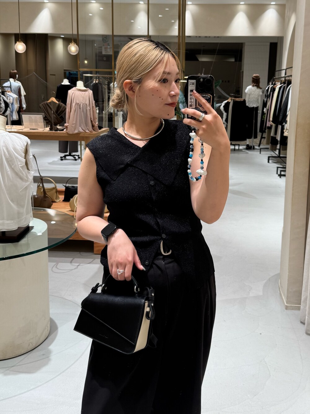 ブラック系のニット/セーター、ブラック系のショルダーバッグ、ブラック系のその他パンツを着用したレディースの夏コーディネートの4枚目の写真