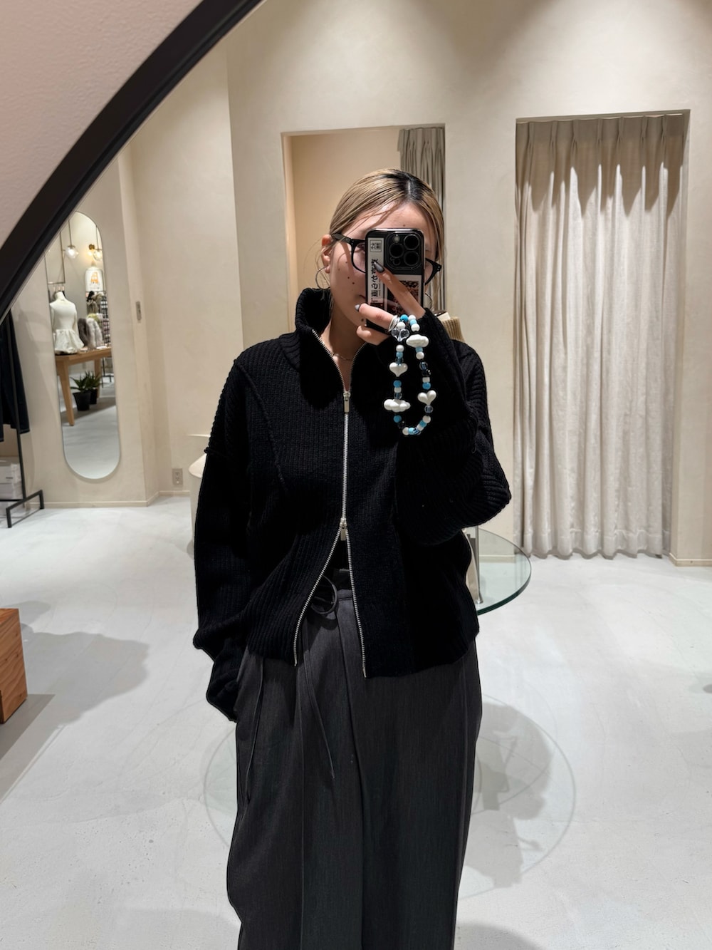 ブラック系のその他パンツ、ホワイト系のバッグ、ブラック系のカーディガン/ボレロを着用したレディースの冬コーディネートの2枚目の写真