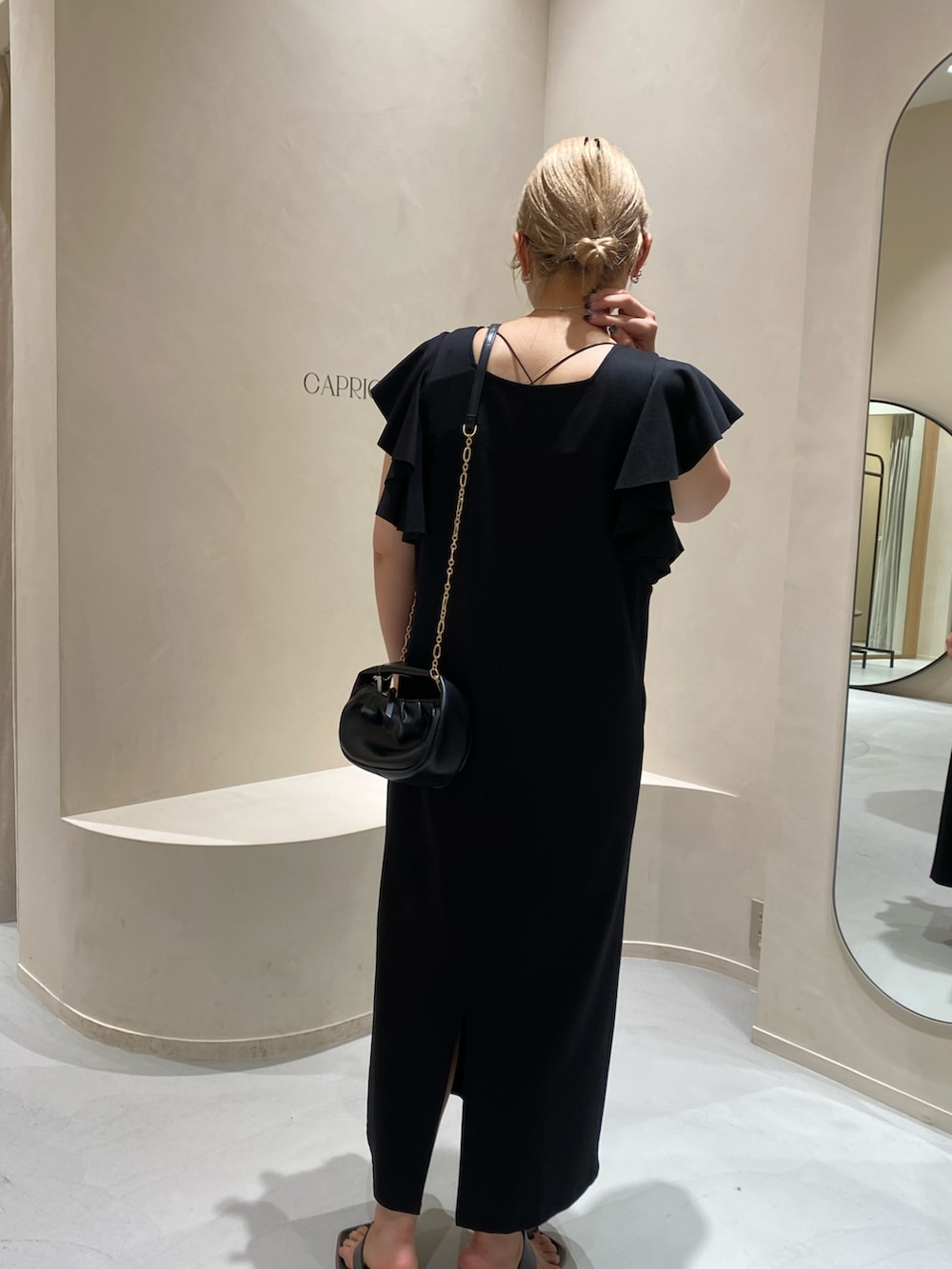 ブラック系のサンダル、ブラック系のワンピースを着用したレディースの夏コーディネートの3枚目の写真