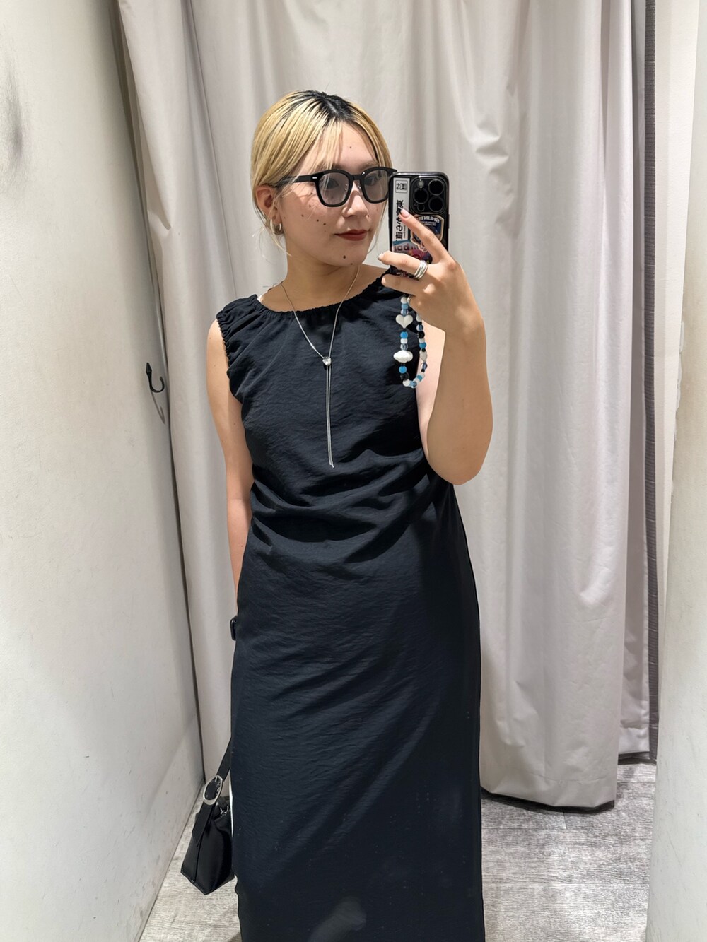 ブラック系のワンピース、ベージュ系のTシャツ/カットソー、ブラック系のショルダーバッグを着用したレディースの夏コーディネートの2枚目の写真