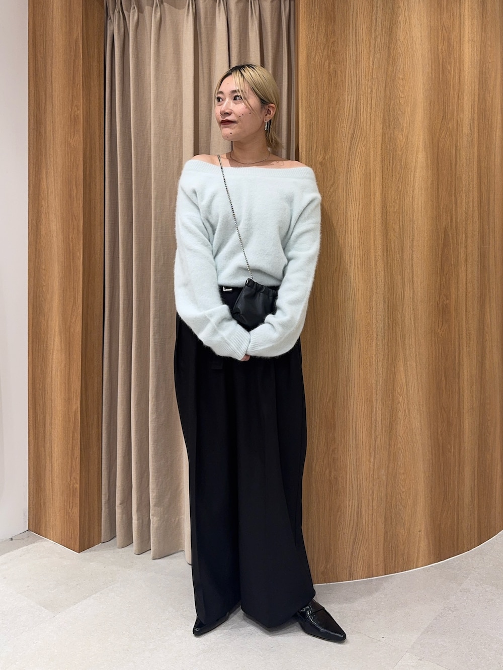 グリーン系のニット/セーター、ブラック系のその他パンツ、ブラック系のショルダーバッグを着用したレディースの秋コーディネートの3枚目の写真