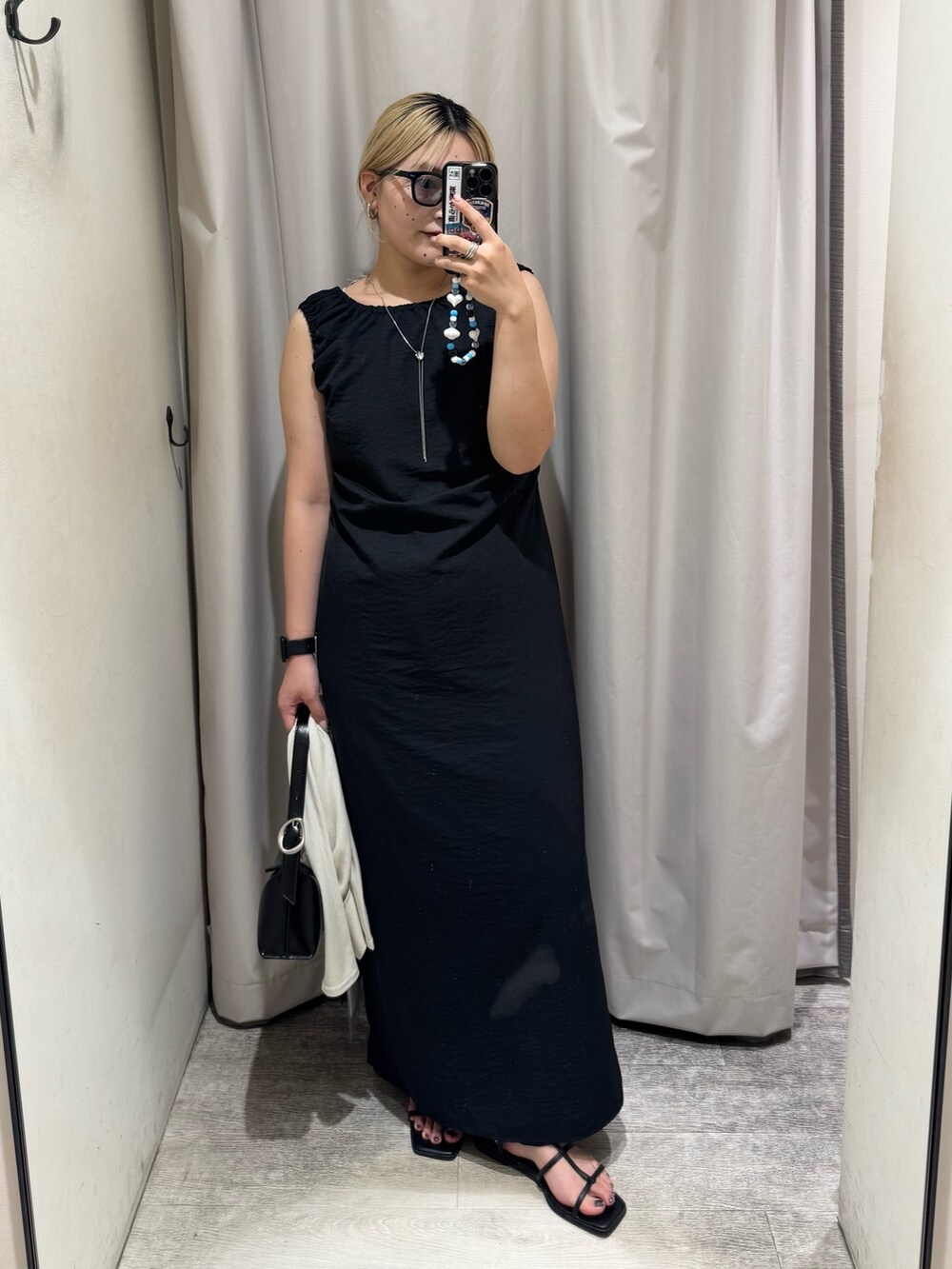 ブラック系のワンピース、ベージュ系のTシャツ/カットソー、ブラック系のショルダーバッグを着用したレディースの夏コーディネートの3枚目の写真