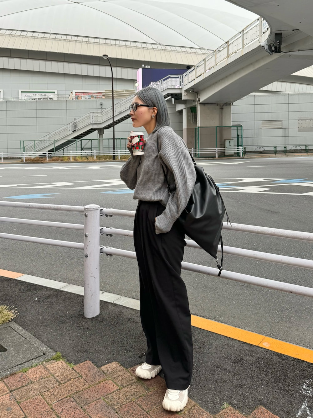 ブラック系のバックパック/リュック、ホワイト系のスニーカー、ブラック系のパンツを着用したレディースの冬コーディネートの2枚目の写真