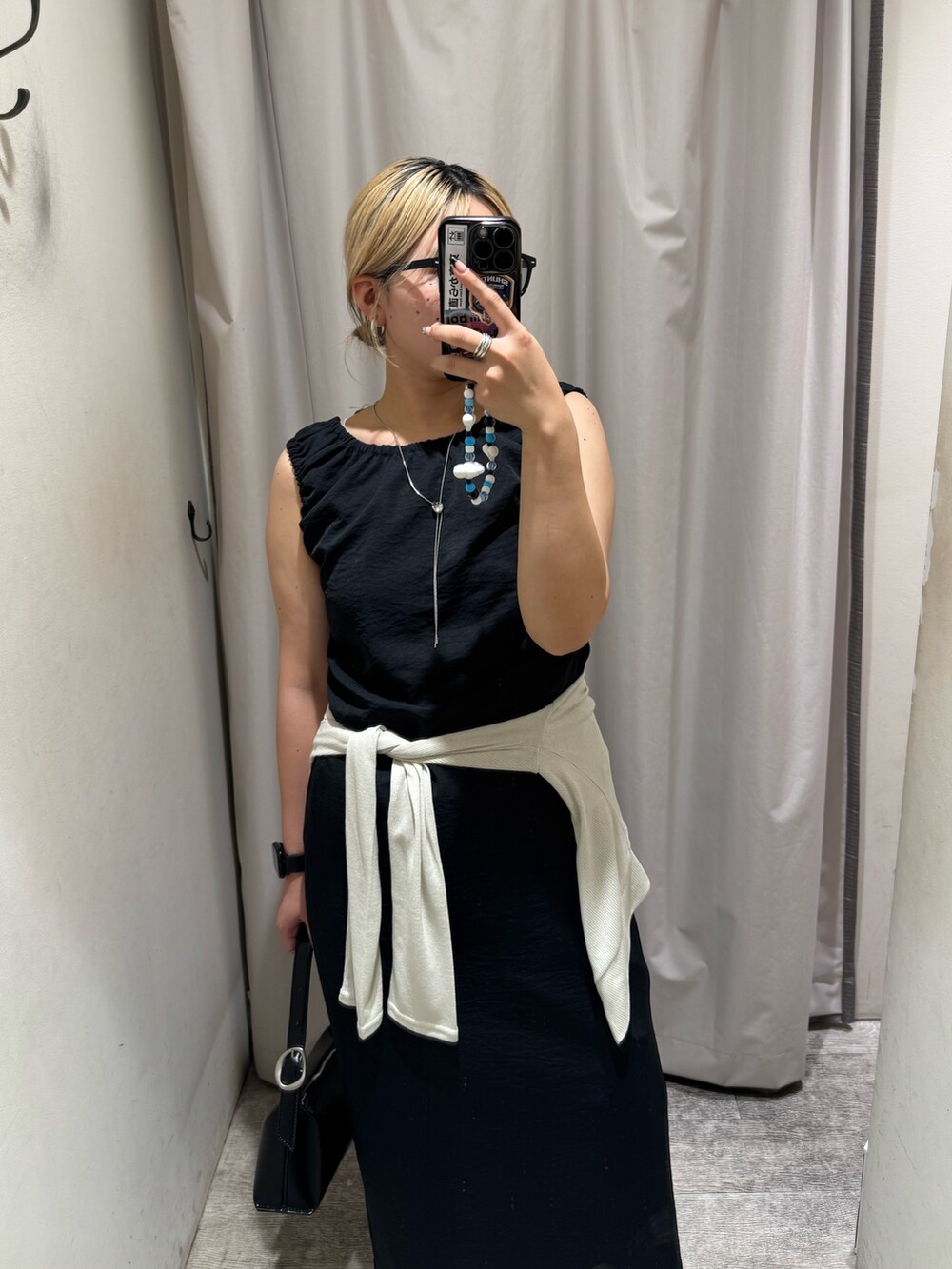 ブラック系のワンピース、ベージュ系のTシャツ/カットソー、ブラック系のショルダーバッグを着用したレディースの夏コーディネートの4枚目の写真