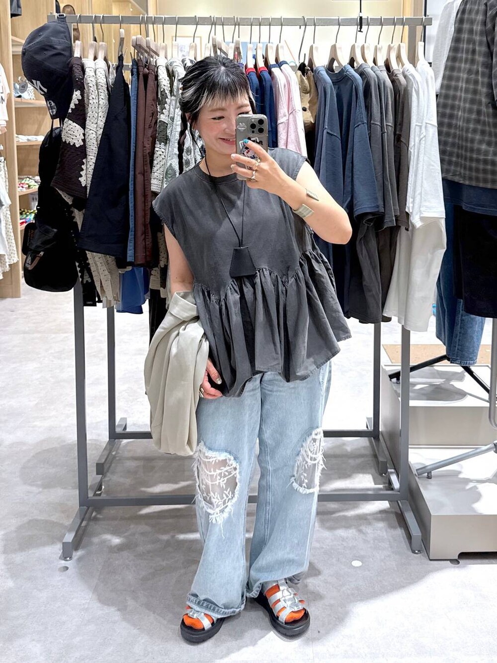 ブルー系のデニムパンツ、ホワイト系のテーラードジャケット、シルバー系のサンダルを着用したレディースの夏コーディネートの5枚目の写真