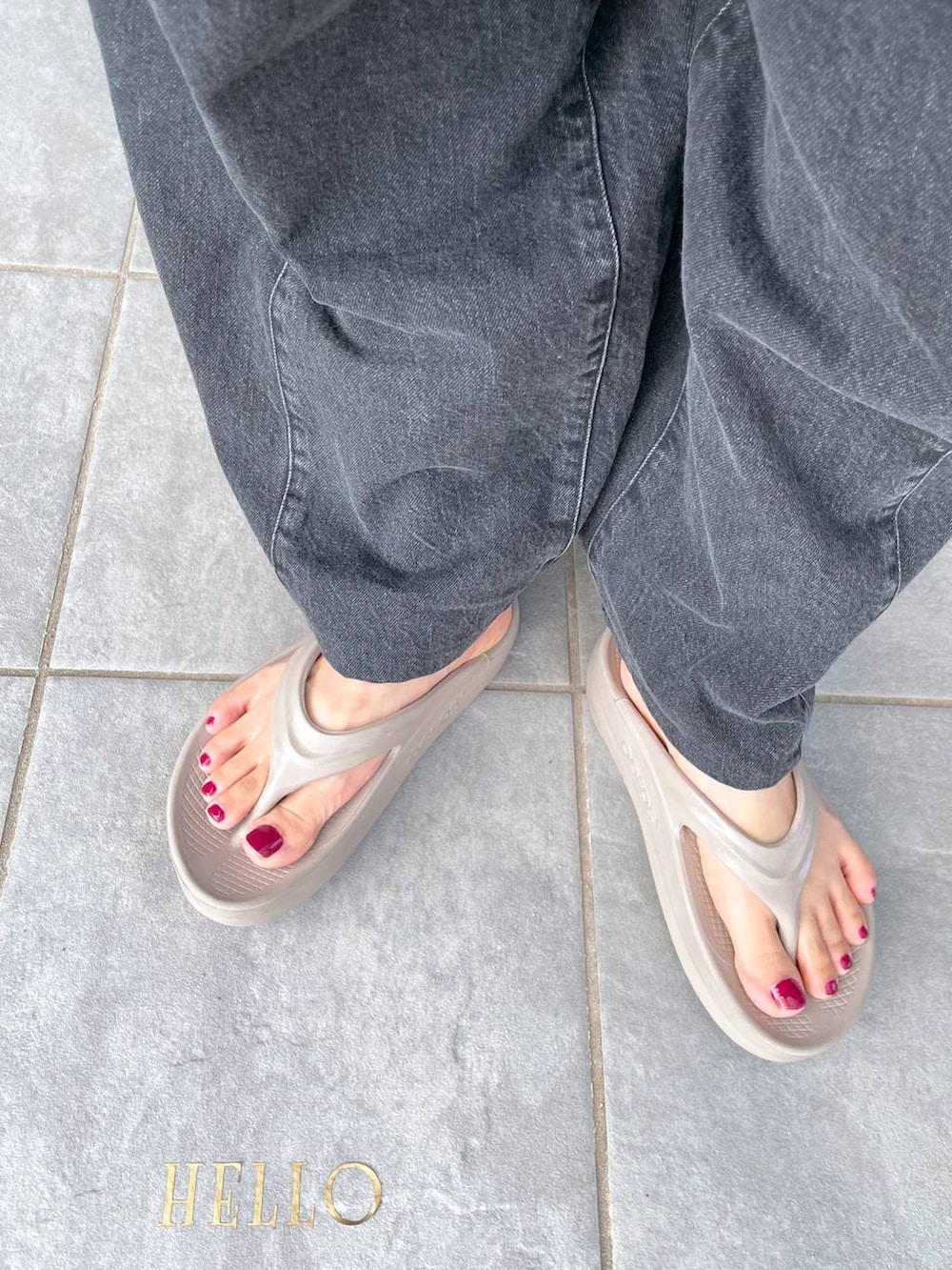 ピンク系のトートバッグ、ベージュ系のサンダル、グレー系のデニムパンツを着用したレディースの夏コーディネートの3枚目の写真