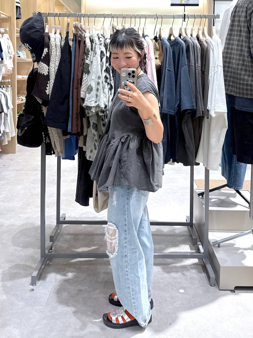 ブルー系のデニムパンツ、ホワイト系のテーラードジャケット、シルバー系のサンダルを着用したレディースの夏コーディネートの6枚目の写真