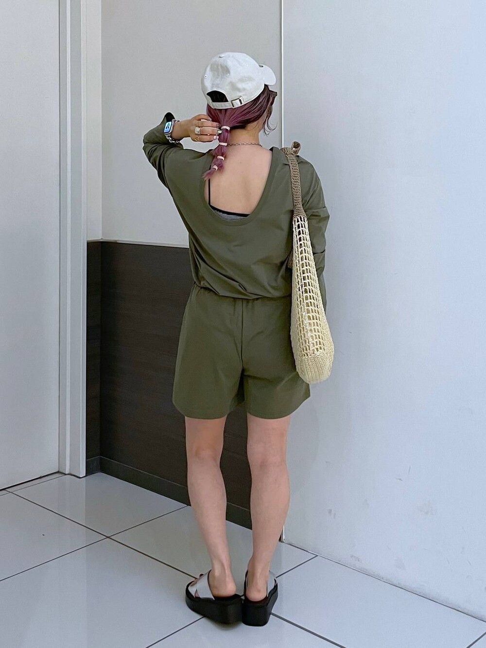 ベージュ系のショルダーバッグ、シルバー系のサンダル、グリーン系のラッシュガードを着用したレディースの夏コーディネートの3枚目の写真