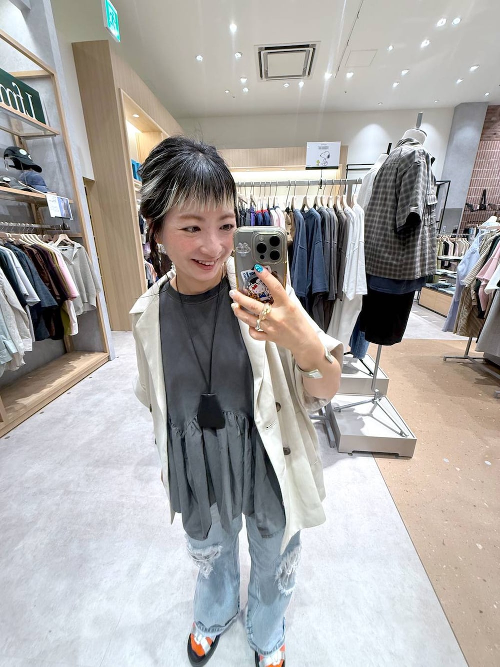 ブルー系のデニムパンツ、ホワイト系のテーラードジャケット、シルバー系のサンダルを着用したレディースの夏コーディネートの2枚目の写真