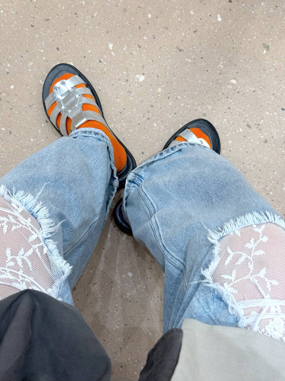 ブルー系のデニムパンツ、ホワイト系のテーラードジャケット、シルバー系のサンダルを着用したレディースの夏コーディネートの7枚目の写真