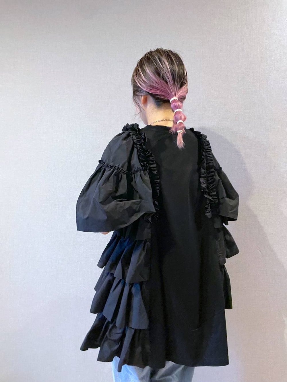 ブラック系のチュニック、グレー系のネックレスを着用したレディースの夏コーディネートの3枚目の写真