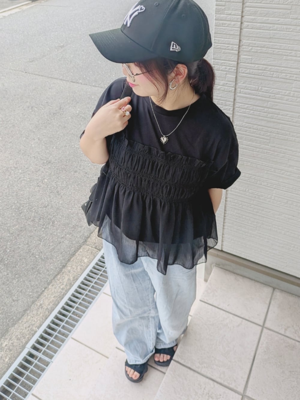 ブラック系のTシャツ/カットソー、ブルー系のデニムパンツ、ブラック系のサンダルを着用したレディースの夏コーディネートの3枚目の写真