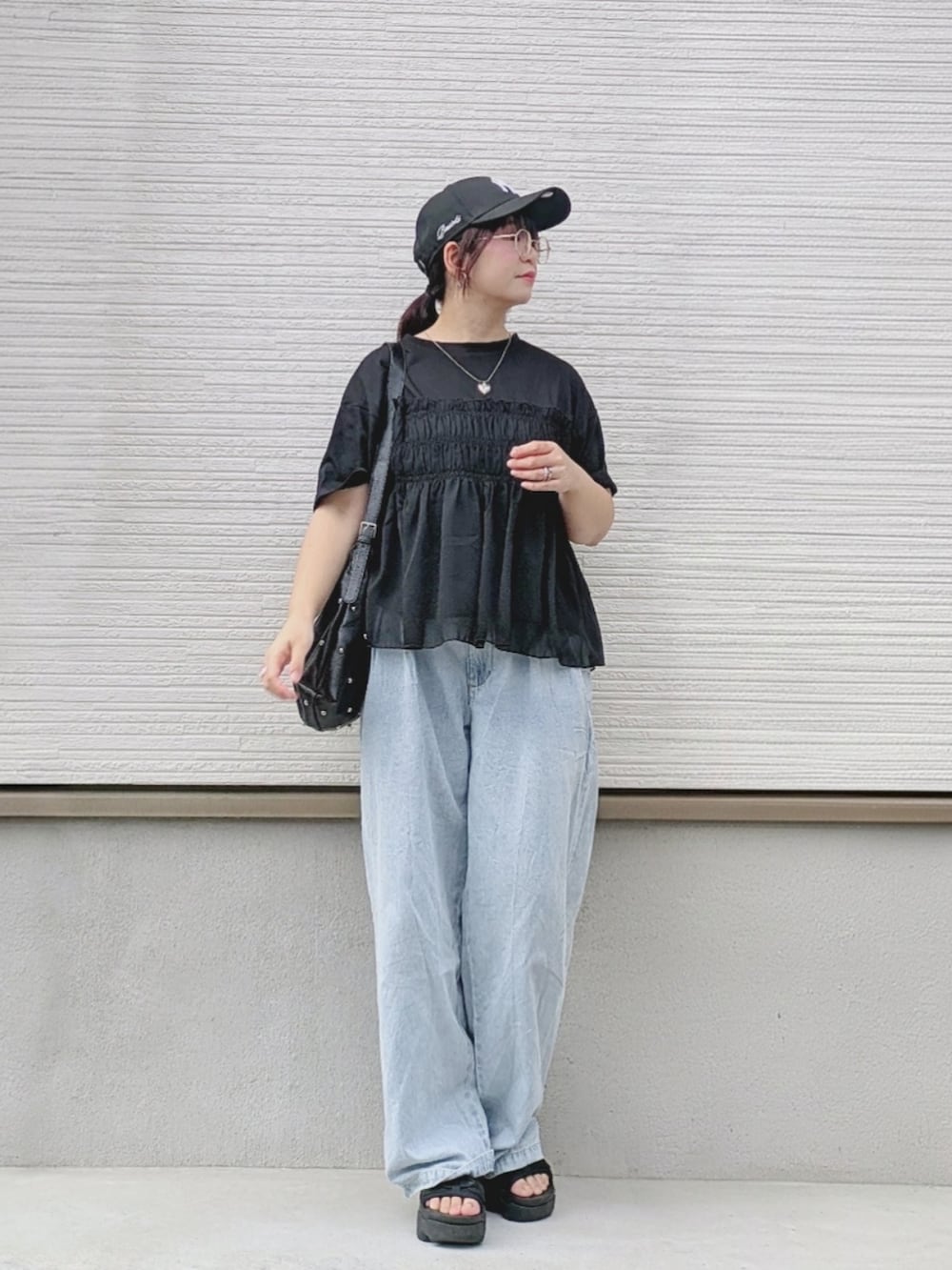 ブラック系のTシャツ/カットソー、ブルー系のデニムパンツ、ブラック系のサンダルを着用したレディースの夏コーディネートの4枚目の写真