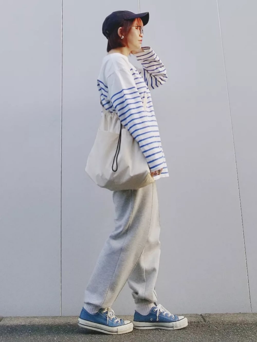 ホワイト系のTシャツ/カットソー、グレー系のスウェットパンツ、ブルー系のスニーカーを着用したレディースの春コーディネートの3枚目の写真