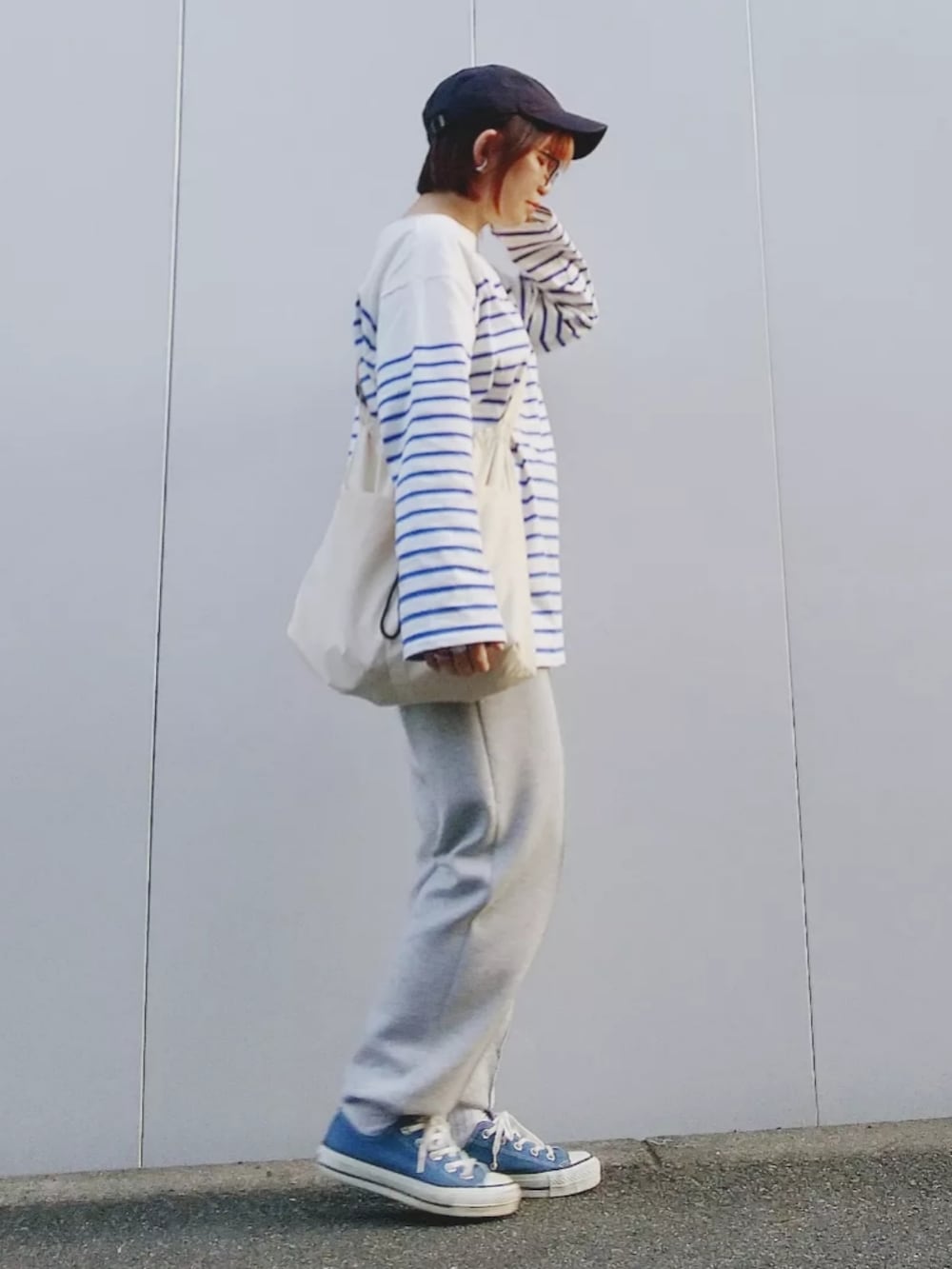 ホワイト系のTシャツ/カットソー、グレー系のスウェットパンツ、ブルー系のスニーカーを着用したレディースの春コーディネートの2枚目の写真