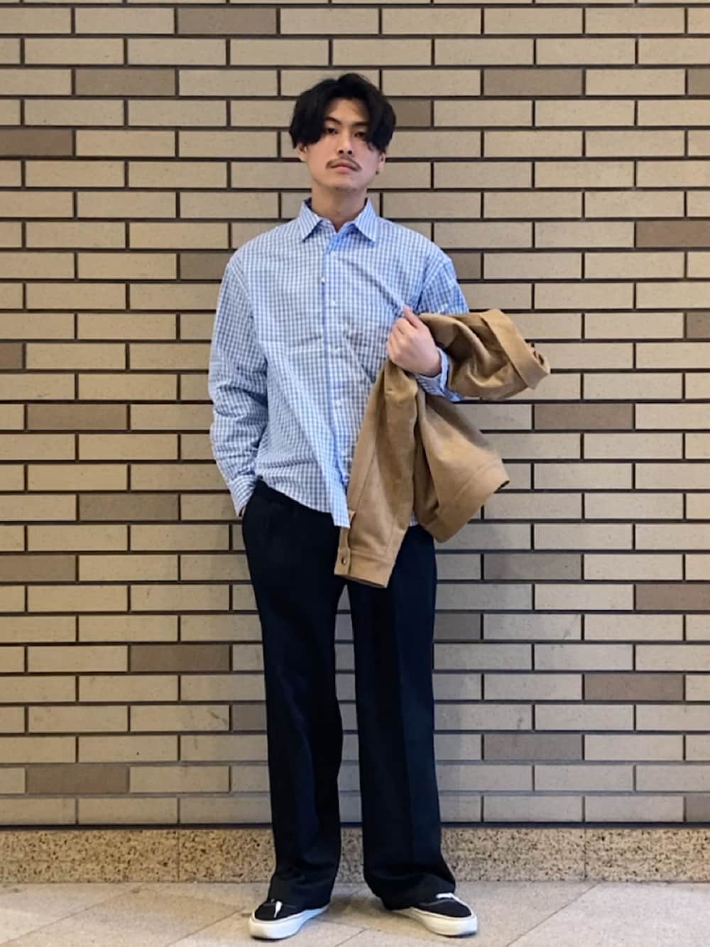 ブラック系のスニーカー、ブラック系のスラックス、ベージュ系のブルゾンを着用したメンズの春コーディネートの2枚目の写真