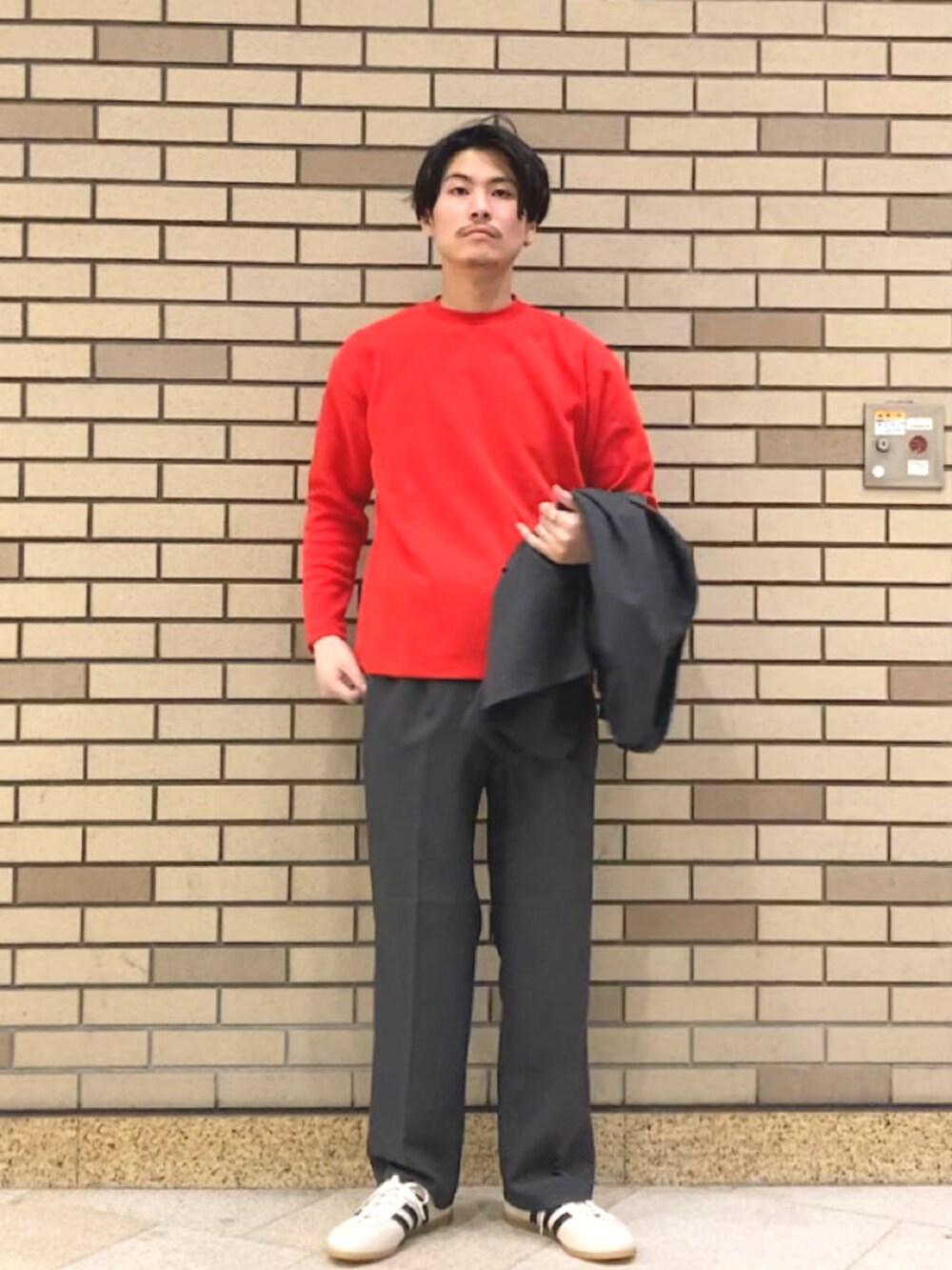 ホワイト系のスニーカー、グレー系のテーラードジャケット、レッド系のTシャツ/カットソーを着用したメンズの春コーディネートの2枚目の写真