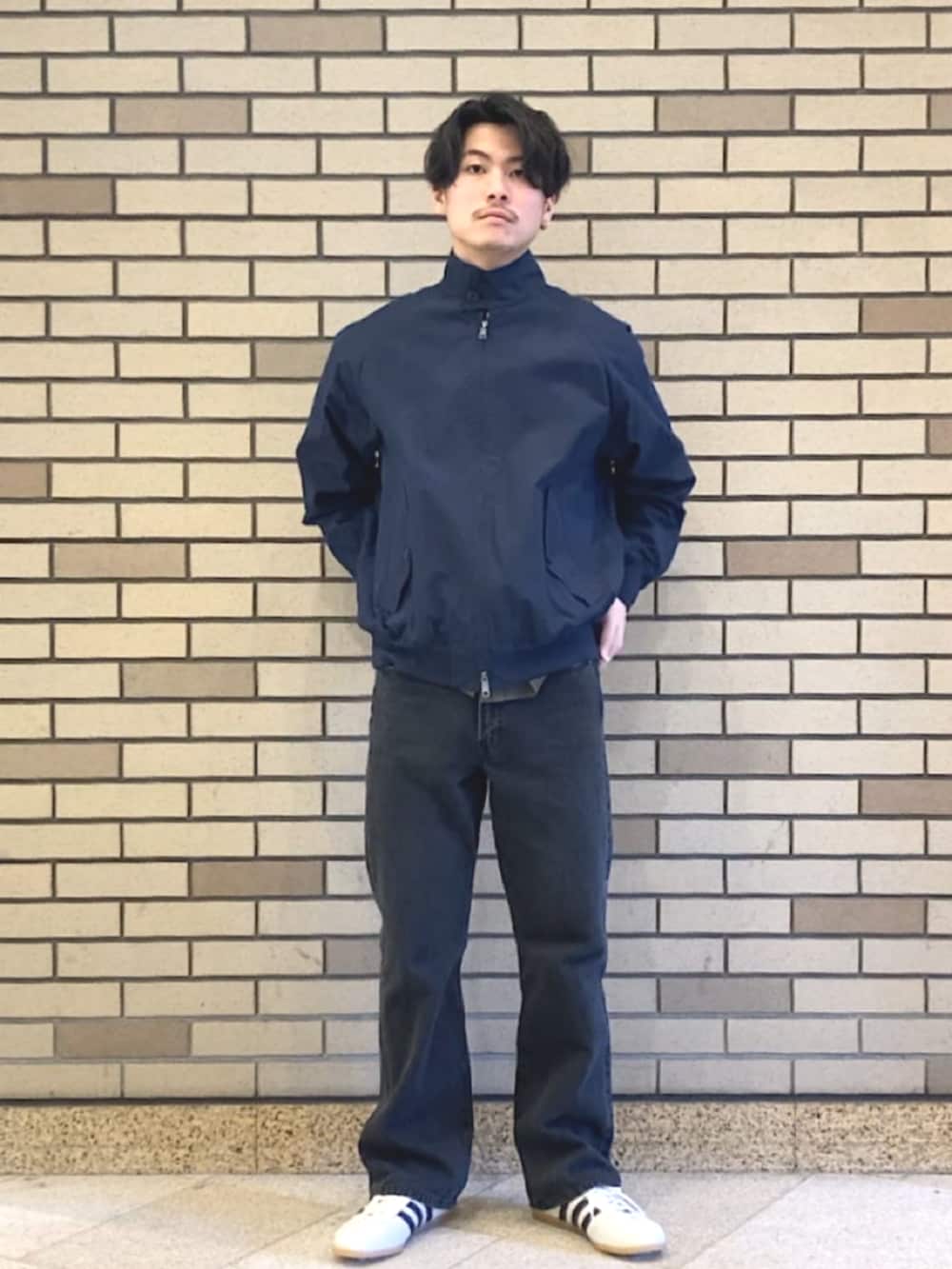 ブルー系のブルゾン、ブラック系のデニムパンツ、ホワイト系のスニーカーを着用したメンズの春コーディネートの2枚目の写真