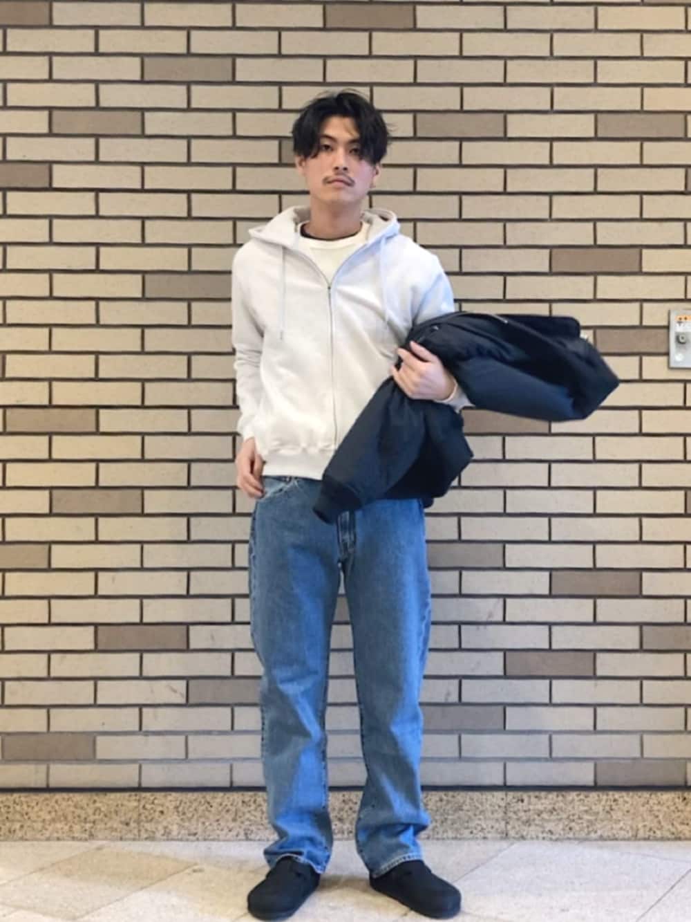 ブルー系のデニムパンツ、ブルー系のブルゾン、グレー系のパーカーを着用したメンズの春コーディネートの2枚目の写真