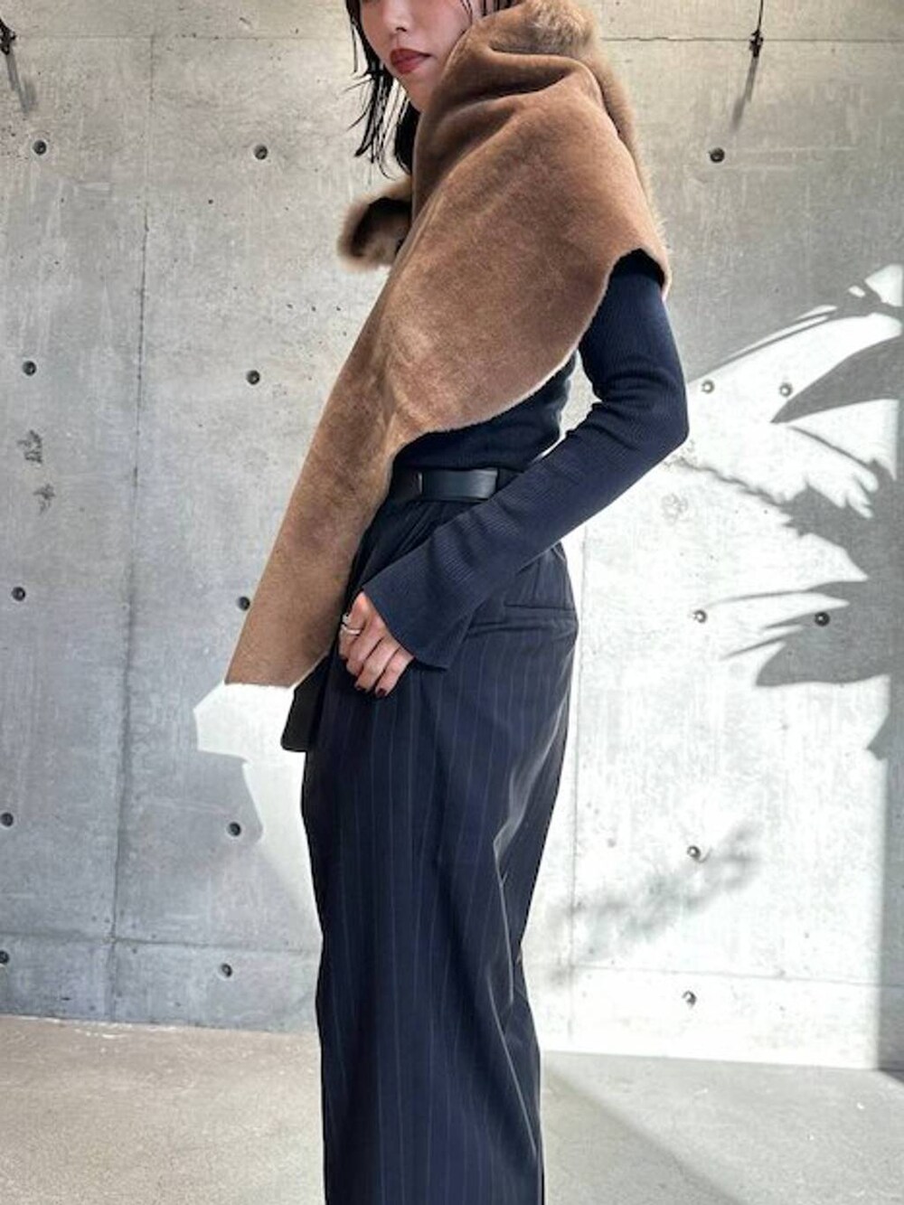 ブルー系のニット/セーター、ブルー系のスラックス、ブラック系のベルトを着用したレディースの秋コーディネートの6枚目の写真