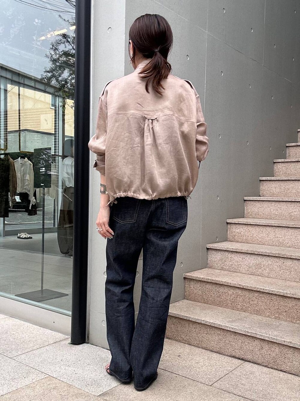 ブラウン系のブルゾン、ブルー系のデニムパンツ、ブラック系のシャツ/ブラウスを着用したレディースの春コーディネートの3枚目の写真