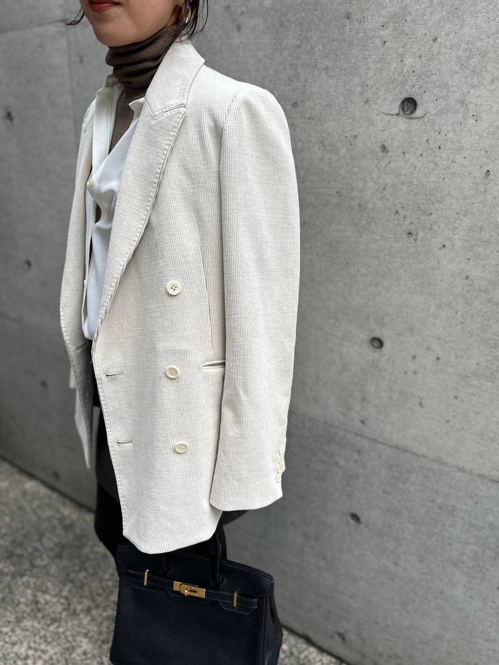 ホワイト系のシャツ/ブラウス、ベージュ系のニット/セーター、グレー系のスカートを着用したレディースの秋コーディネートの7枚目の写真