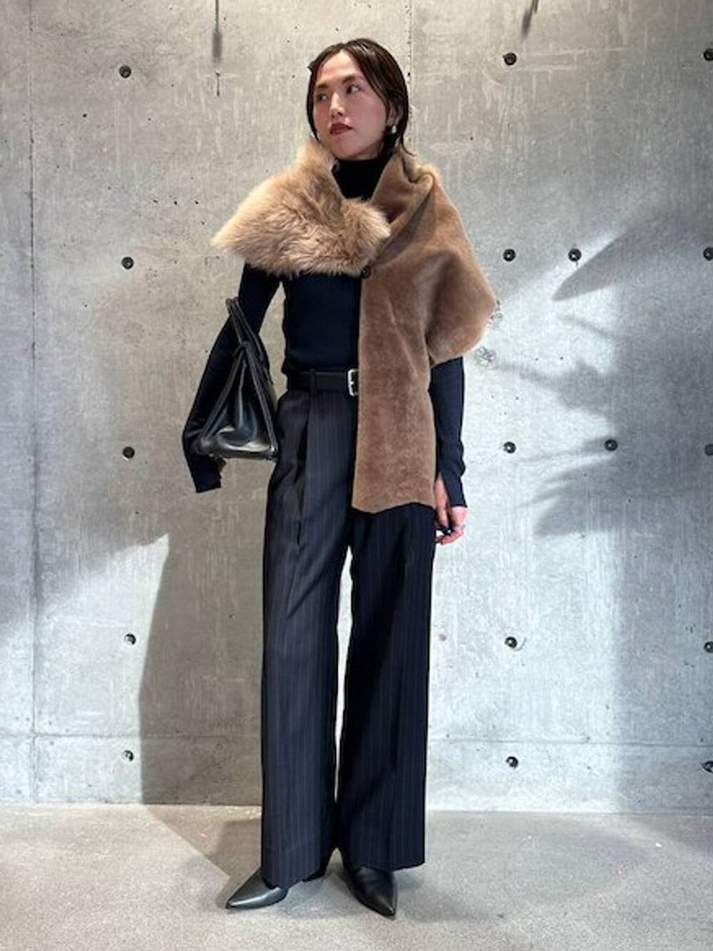 ブルー系のニット/セーター、ブルー系のスラックス、ブラック系のベルトを着用したレディースの秋コーディネートの2枚目の写真