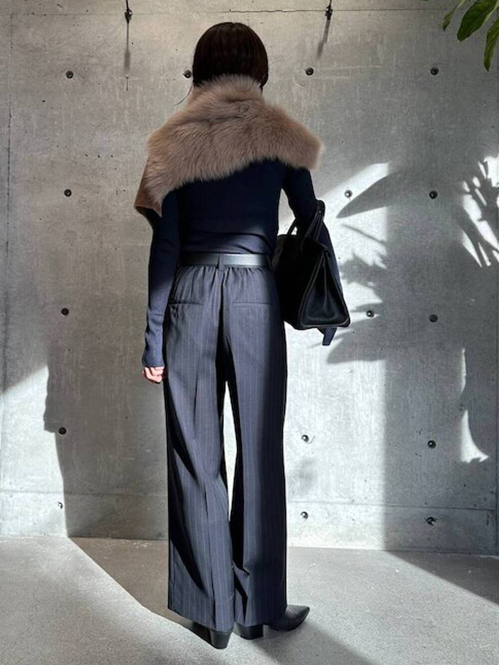 ブルー系のニット/セーター、ブルー系のスラックス、ブラック系のベルトを着用したレディースの秋コーディネートの4枚目の写真