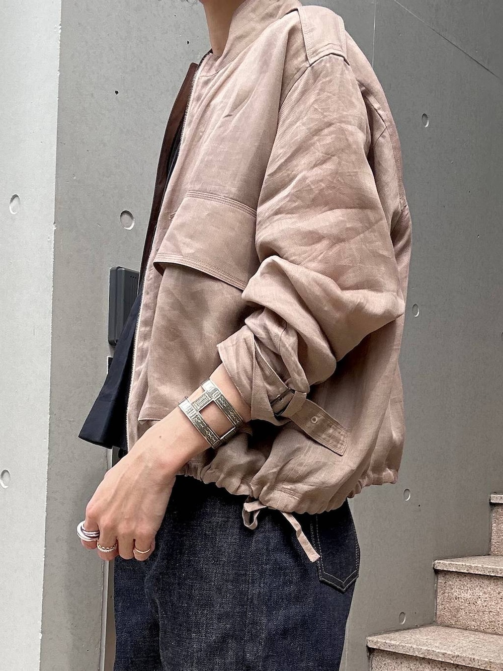 ブラウン系のブルゾン、ブルー系のデニムパンツ、ブラック系のシャツ/ブラウスを着用したレディースの春コーディネートの5枚目の写真