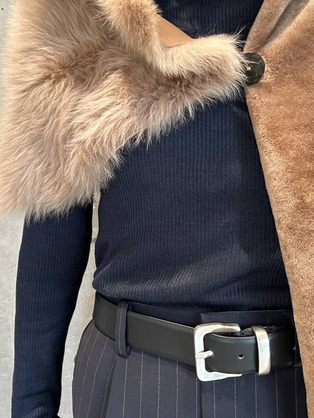 ブルー系のニット/セーター、ブルー系のスラックス、ブラック系のベルトを着用したレディースの秋コーディネートの7枚目の写真