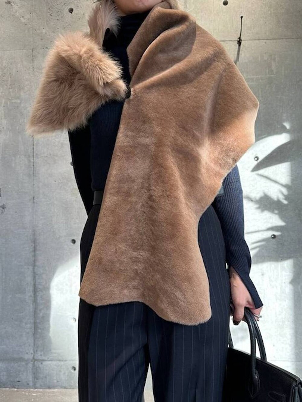 ブルー系のニット/セーター、ブルー系のスラックス、ブラック系のベルトを着用したレディースの秋コーディネートの5枚目の写真