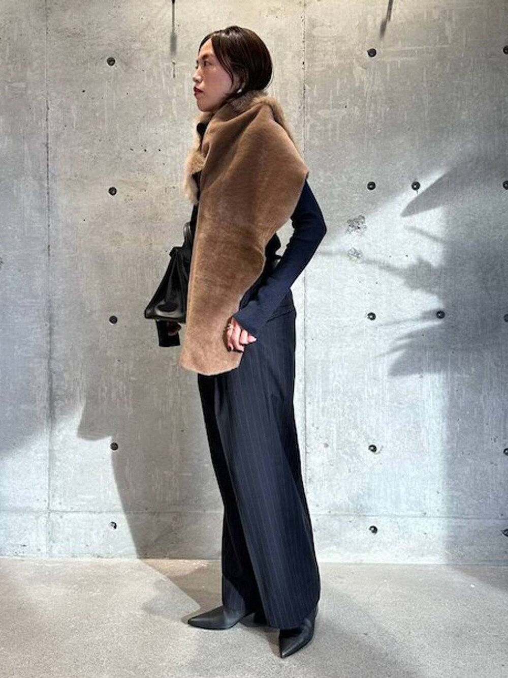 ブルー系のニット/セーター、ブルー系のスラックス、ブラック系のベルトを着用したレディースの秋コーディネートの3枚目の写真