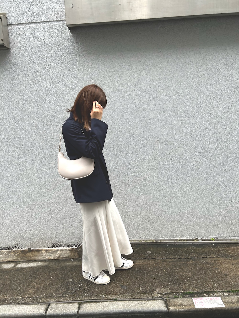 ピンク系のニット/セーター、ホワイト系のスカート、ブルー系のテーラードジャケットを着用したレディースの春コーディネートの2枚目の写真