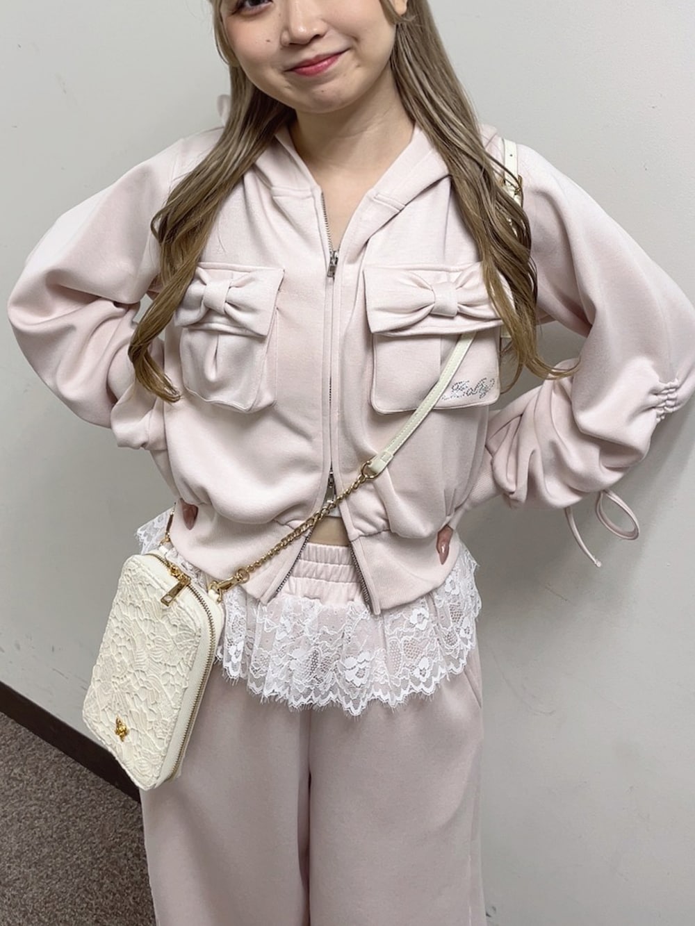 ピンク系のスウェットパンツ、ピンク系のTシャツ/カットソー、ホワイト系のショルダーバッグを着用したレディースの冬コーディネートの2枚目の写真
