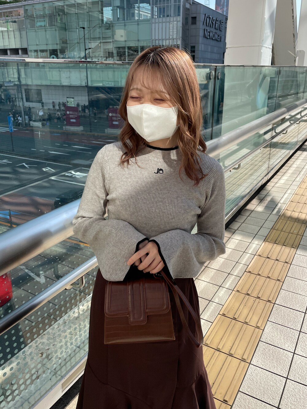 ブラウン系のスカート、ブラウン系のブーツ、ブラウン系のショルダーバッグを着用したレディースの秋コーディネートの2枚目の写真