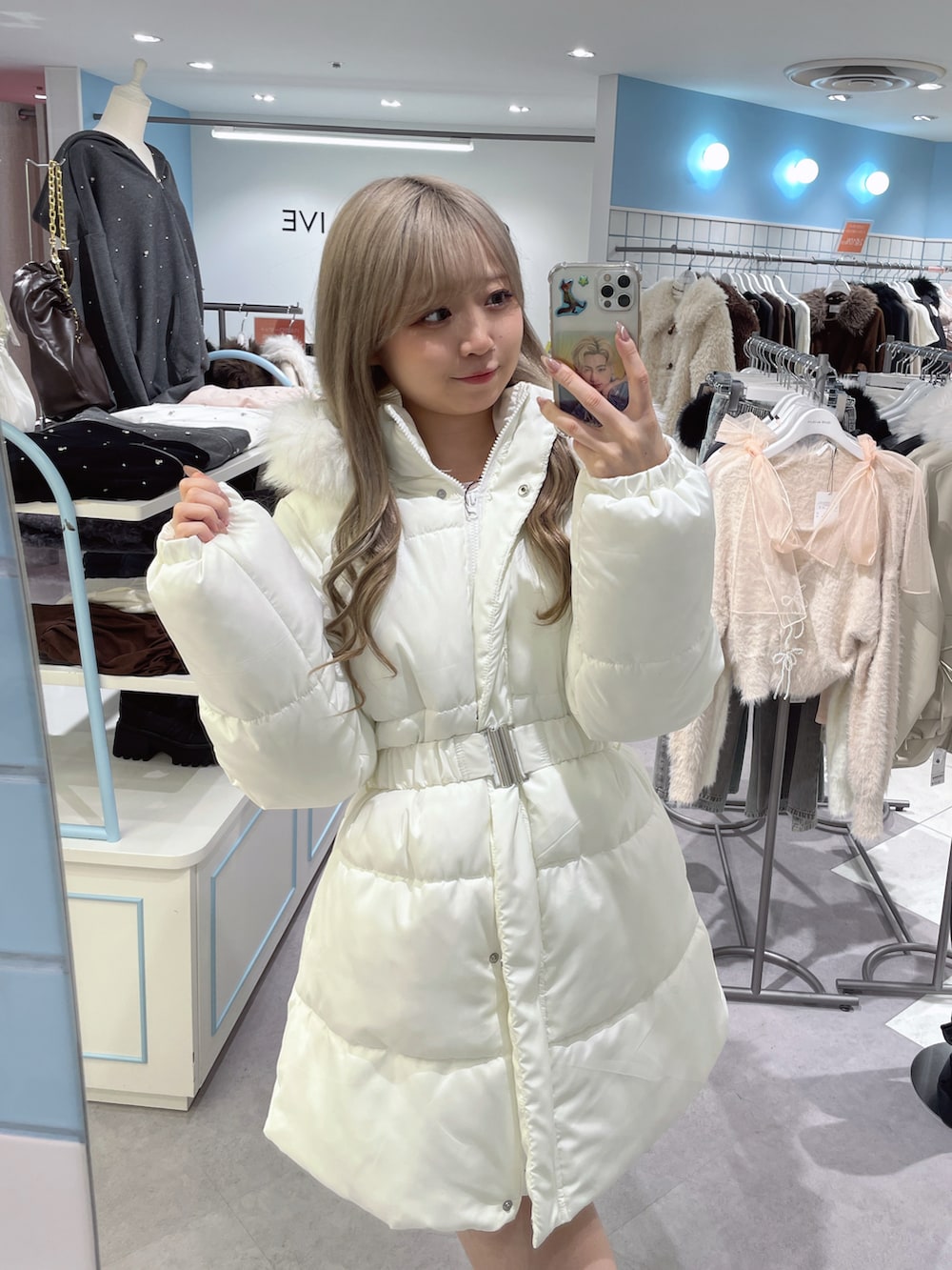 ホワイト系のダウンジャケット/コート、ホワイト系のショルダーバッグを着用したレディースの冬コーディネートの2枚目の写真