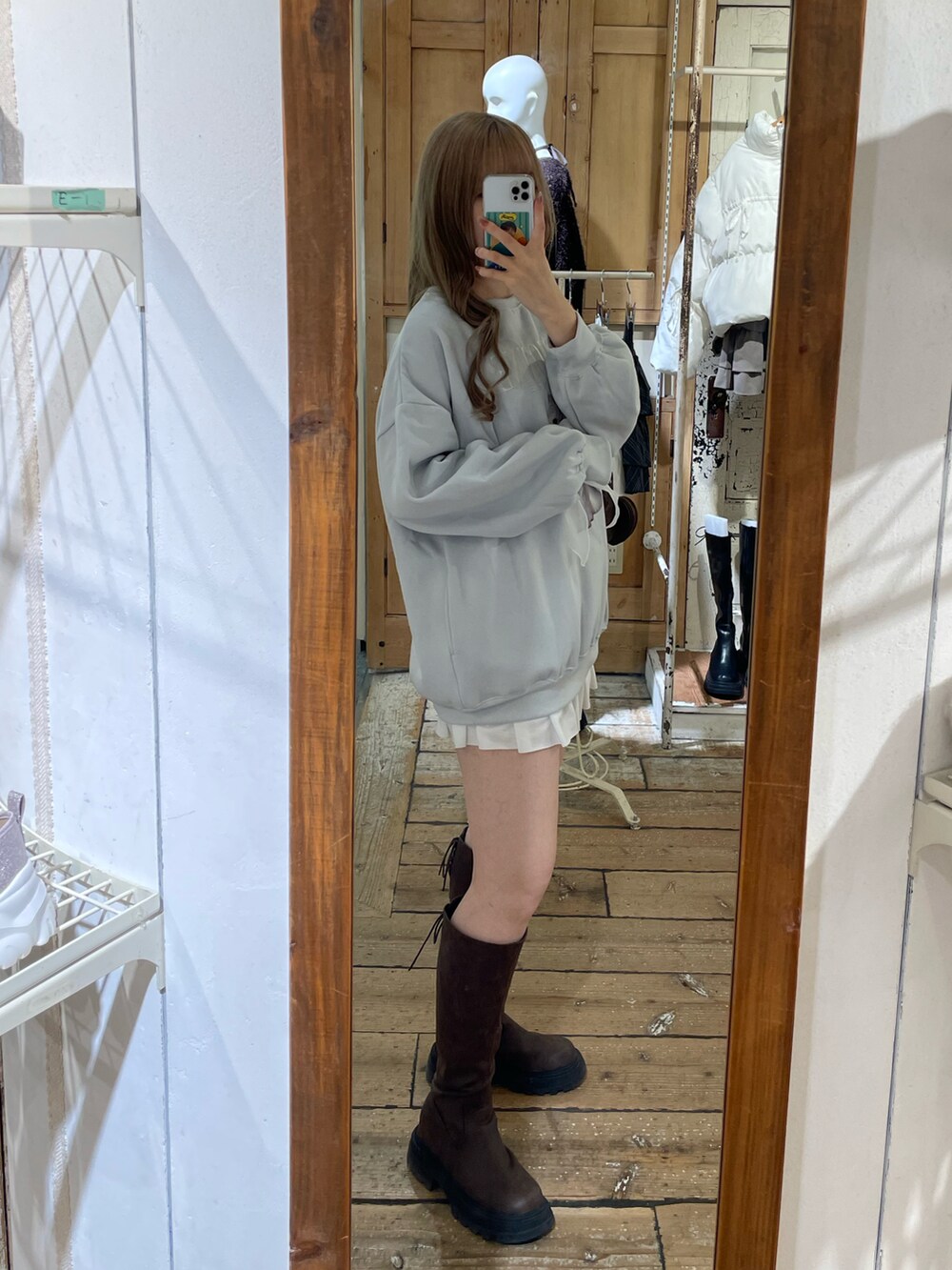 ブルー系のTシャツ/カットソー、ホワイト系のスカート、ブラウン系のブーツを着用したレディースの秋コーディネートの3枚目の写真